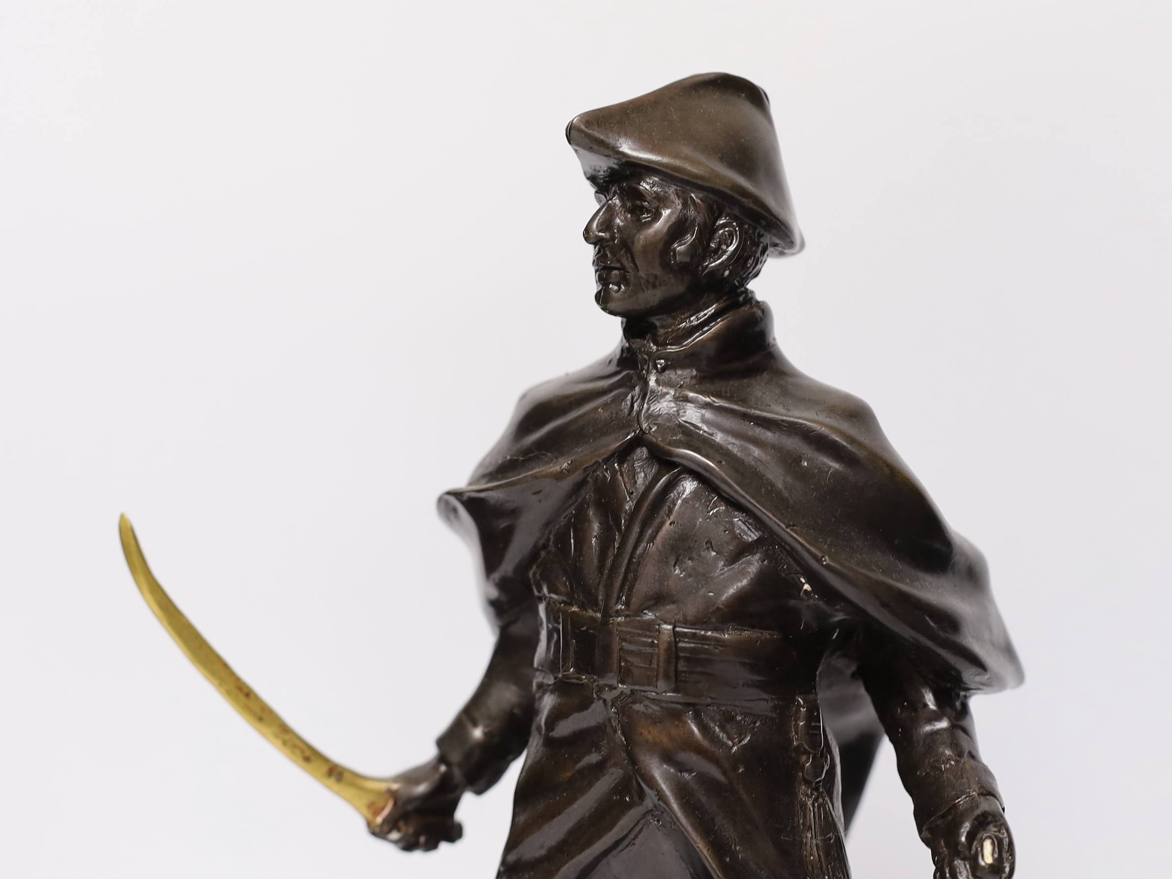 A bronze figure of Wellington with brass sword blade and cannon, signed ‘Boucher’, mounted on a marble base, 34cm